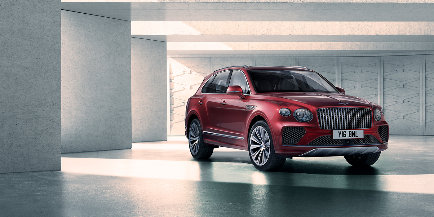 Bentley Glasgow Bentley Bentayga Atelier Edition SUV in Rubino Red paint front three quarter against textured concrete wall