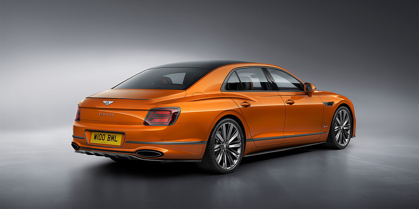Bentley Glasgow Bentley Flying Spur Speed in Orange Flame colour rear view, featuring Bentley insignia and enhanced exhaust muffler.