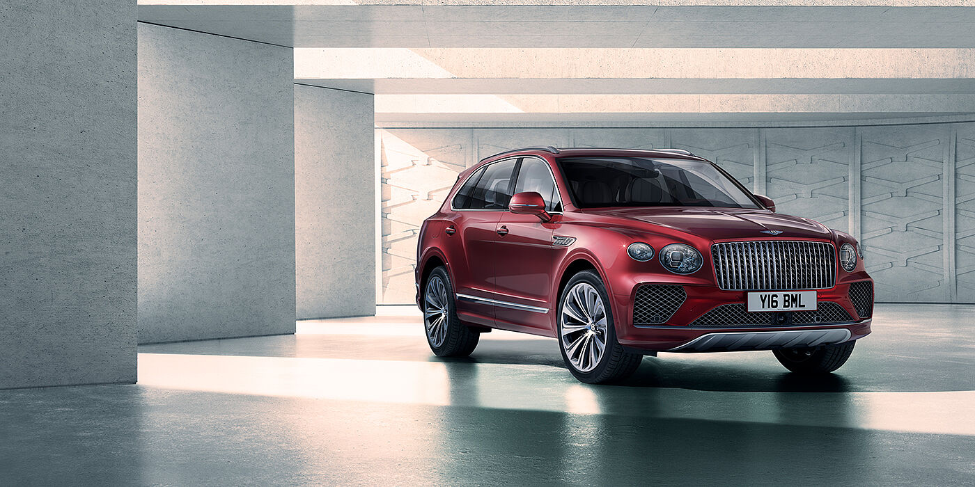 Bentley Glasgow Bentley Bentayga Atelier Edition SUV in Rubino Red paint front three quarter against textured concrete wall
