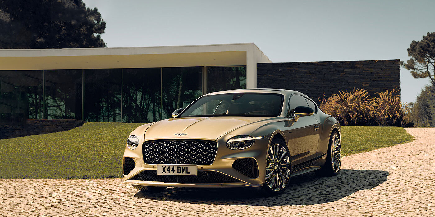 Bentley Glasgow Bentley Continental GT Mulliner coupe front three quarters in Patina paint parked outside a glass fronted building with a grass lawn behind it
