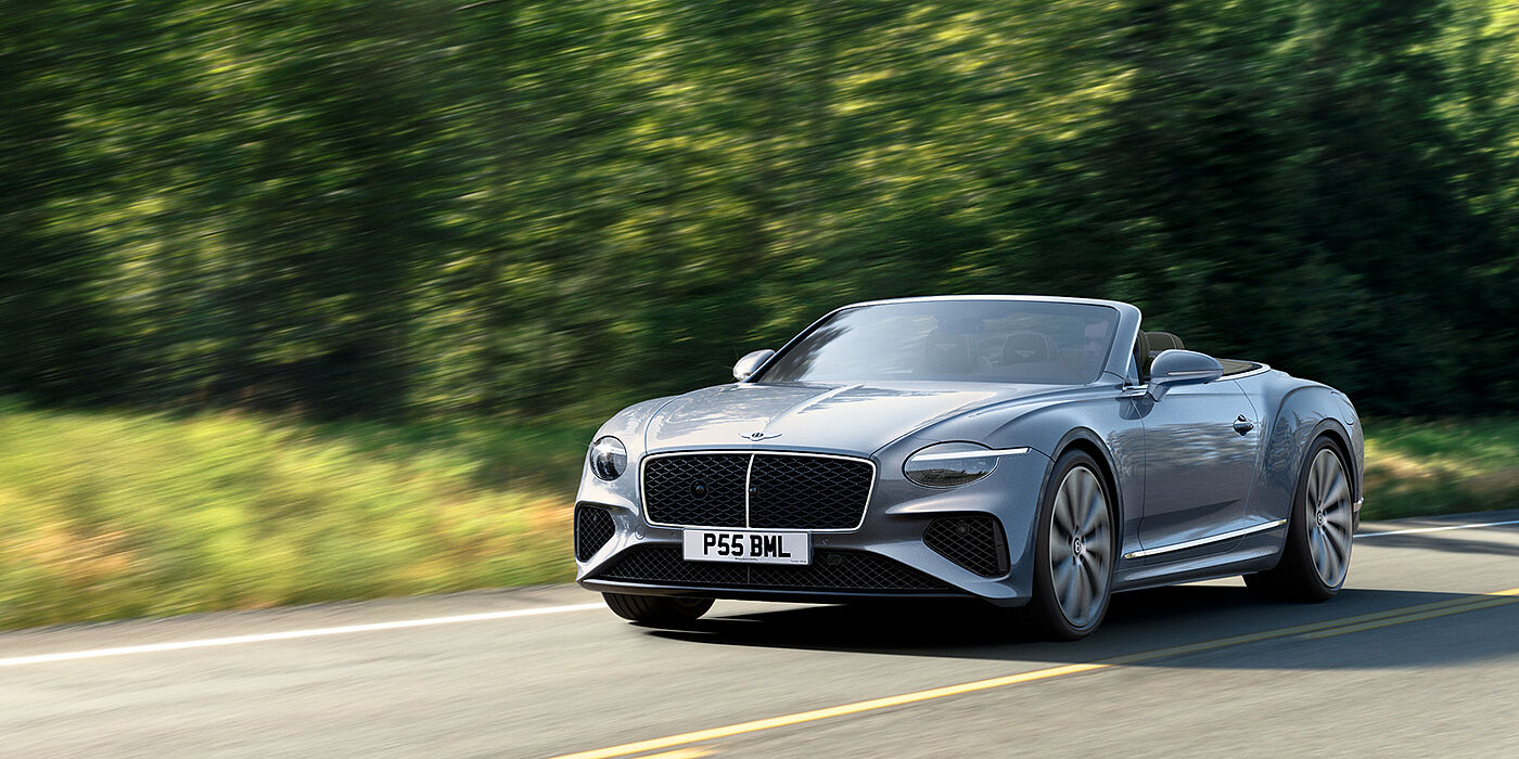 Bentley Glasgow New Bentley Continental GTC convertible front view in Silverlake paint with 22 inch ten spoke wheels, driving dynamically on a country road