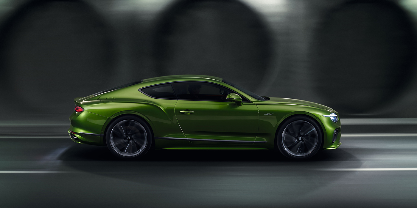 Bentley Glasgow Bentley Continental GT coupe in Tourmaline Green paint driving in profile on a dark road
