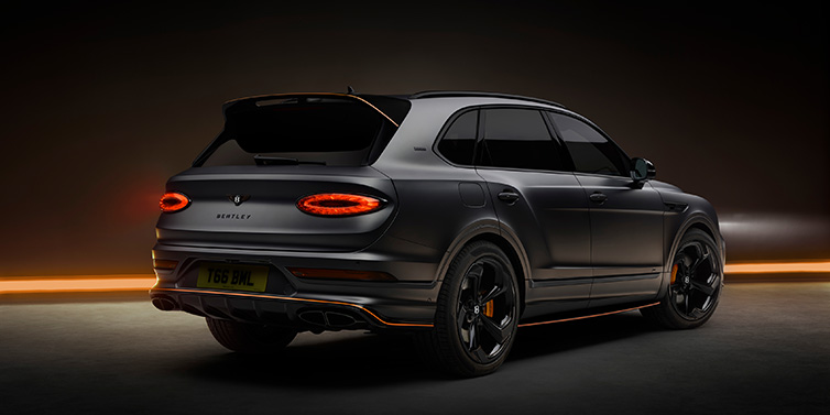 Bentley Glasgow Bentley Bentayga S Black Edition SUV rear three quarter in Anthracite Satin paint against a dark red and yellow background