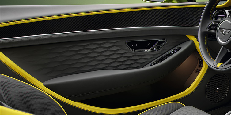 Bentley Glasgow Bentley Continental GTC Speed convertible interior door details featuring Gravity Grey and Cyber Yellow by Mulliner hides and high gloss carbon fibre veneer