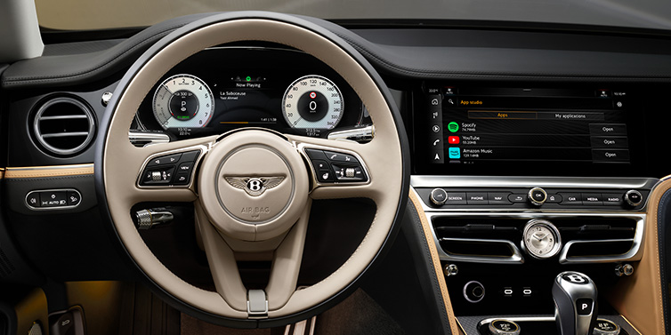 Bentley Glasgow Bentley Flying Spur Mulliner sedan front interior detail of steering wheel and driver screens surrounded by Linen and Beluga black hides