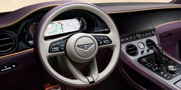 Bentley Glasgow Bentley Continental GT Mulliner coupe front interior showing steering wheel and drivers screens surrounded by Linen and Damson hides and Grand Black veneer